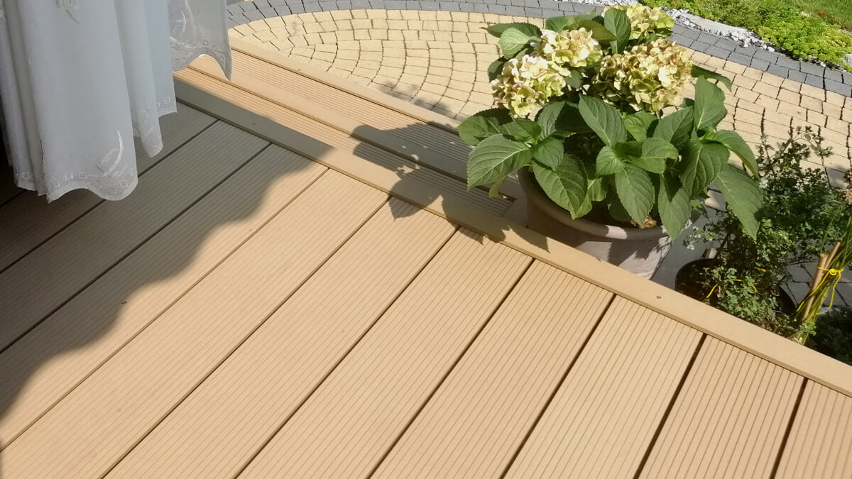 Ein stimmungsvoller Terrassenbereich aus WPC-Terrassendielen Premium Amber
