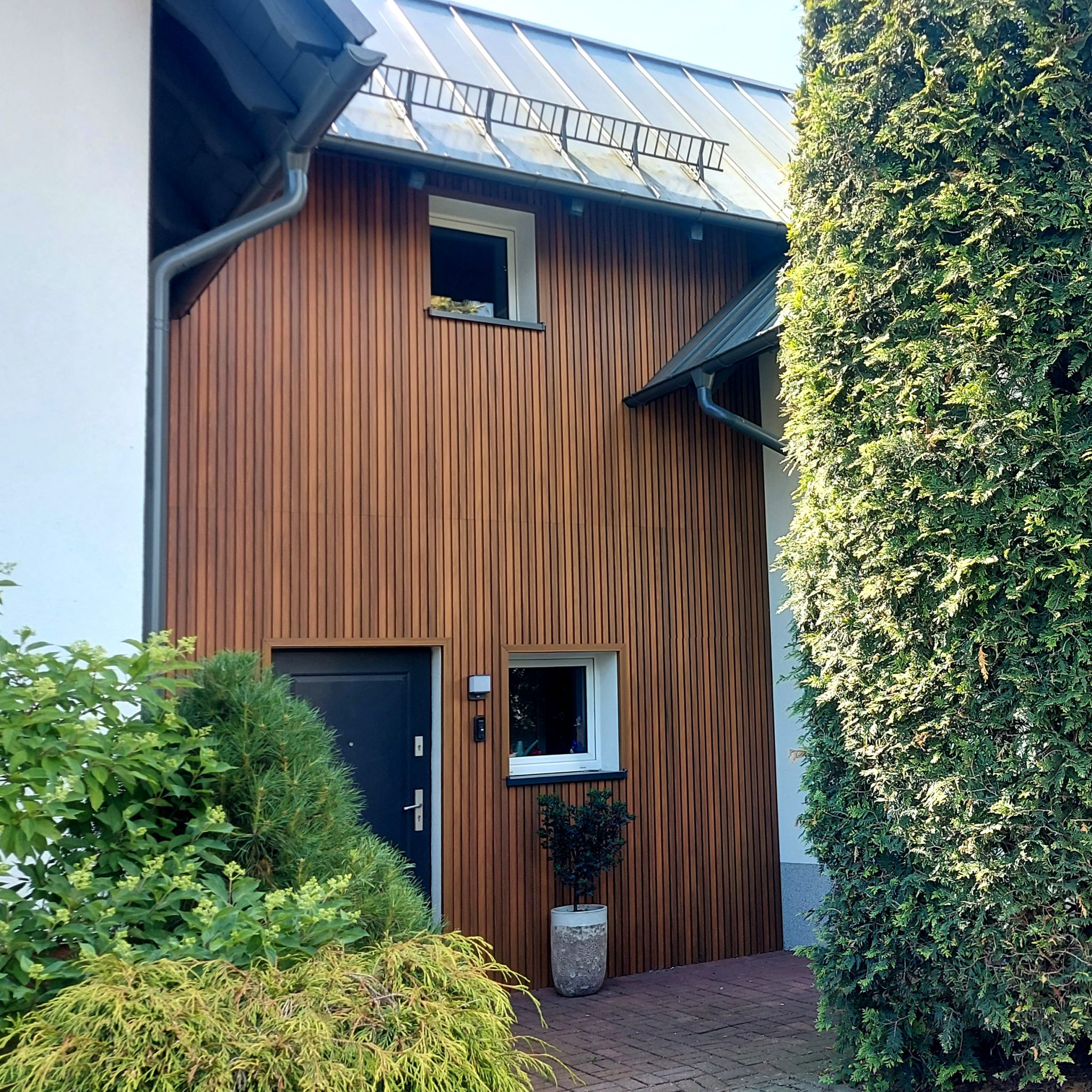 Moderne Fassade mit WPC Fassadenlamellen Premium Amber